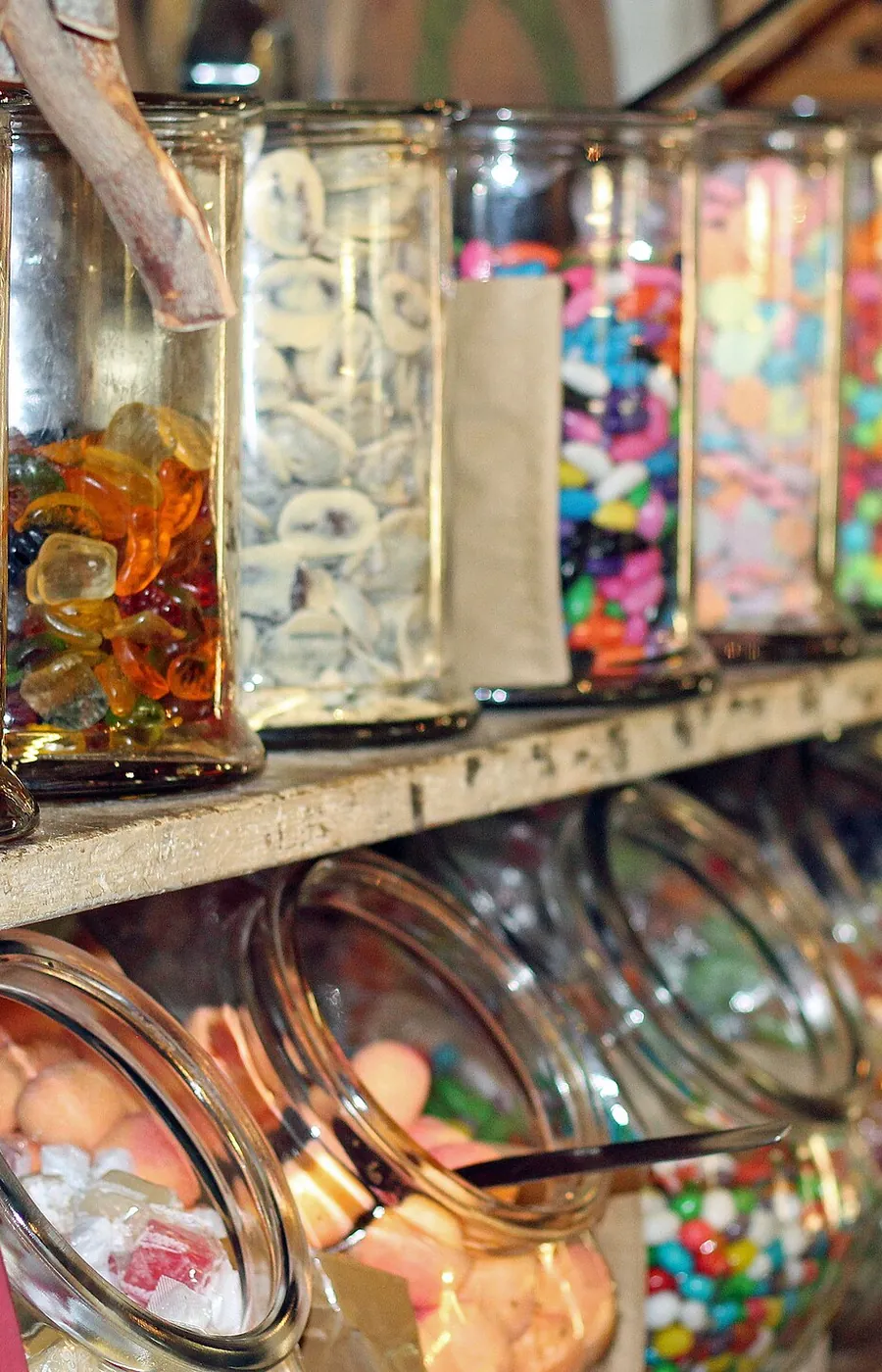 Jars of loose sweets lined up on the shelves of a sweets house
